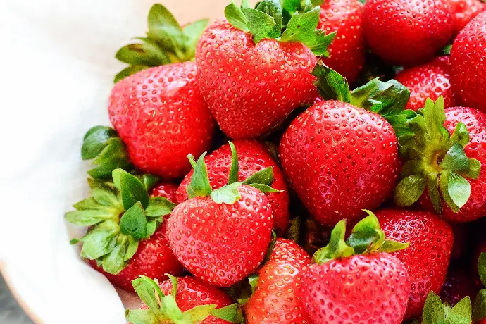 strawberries on white bowl